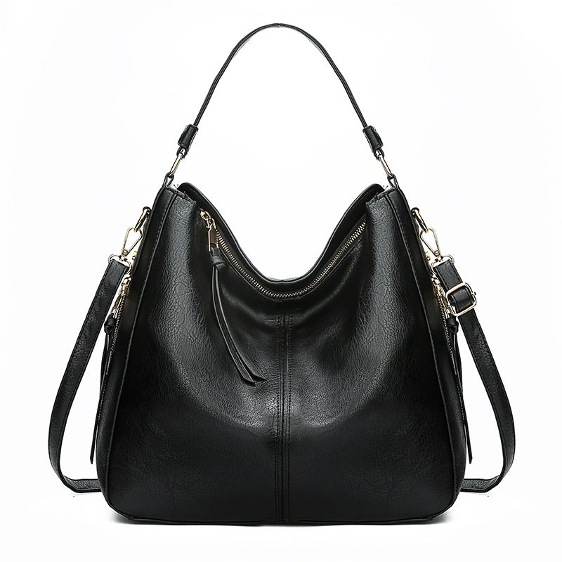 Black zipper bucket bag with adjustable shoulder straps and gold zipper trim