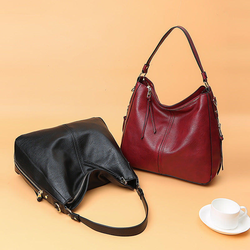 Red zipper bucket bag with adjustable straps and small black crossbody pouch