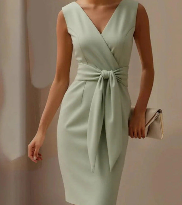 Mint green dress with a bow detail on a neutral background