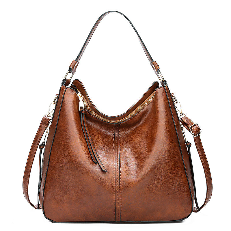 Tan brown zipper bucket bag with adjustable shoulder straps and gold hardware