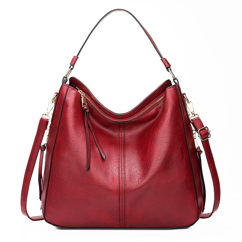 Hobo bucket handbag with zip top and adjustable shoulder strap, red leather-look